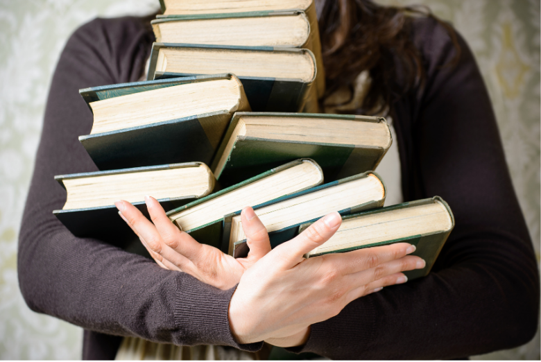 Reading and student college concept. Woman holding a pile of old books for studying concept. Female librarian hands.